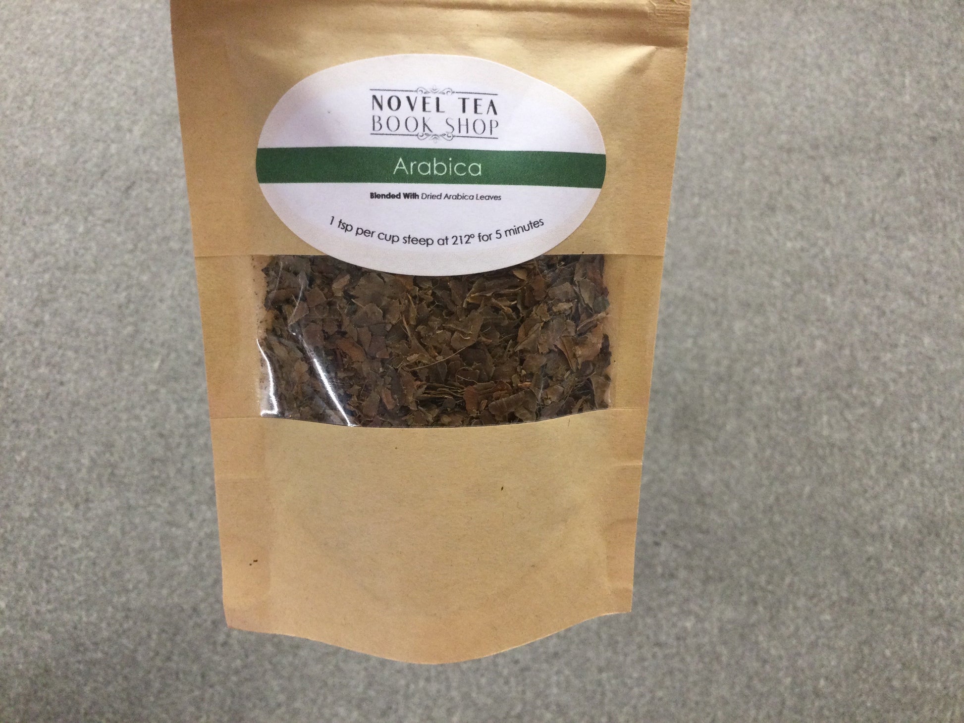 Loose leaf Arabica herbal tea in a jar, showcasing dried tea leaves from Novel Tea Book Shop.