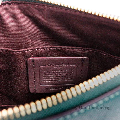 Coach Rowan Mini Dark Pine leather crossbody bag with sleek design and adjustable strap, ideal for carrying essentials.