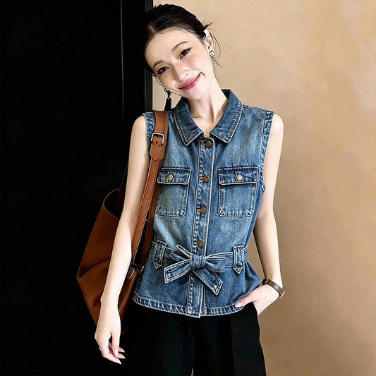 Washed-and-faded white sleeveless denim vest with a classic cut and button front