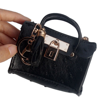 Solid color leather mini handbag with decorative tassel and compact fashion design