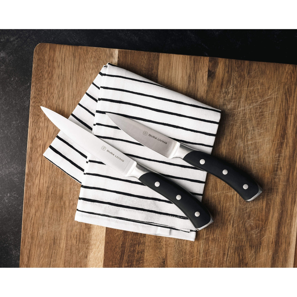 Dura Living Elite 3-piece black kitchen knife set with stainless steel blades and ergonomic handles on a countertop.