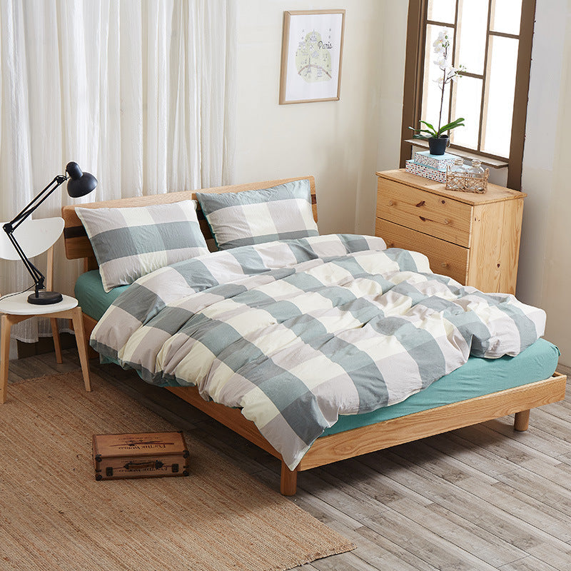 Pure cotton four-piece bed sheet set with soft fabric and coordinated bedding pieces in neutral tones