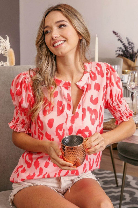 Leopard print smocked short sleeve blouse by Trendsi, featuring trendy style and lightweight fabric, displayed on a hanger.