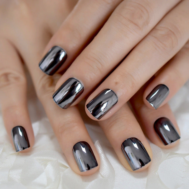 Metal false nails for women, close-up of silver metallic artificial nail tips