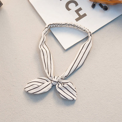 Big bow tie bunny ears headband, featuring oversized bow and soft rabbit ears in a playful design