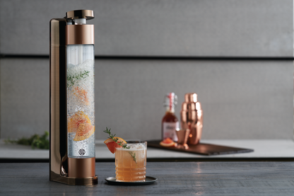 Qarbo FizzMaster sparkling water and fruit infuser in bronze, featuring a sleek design for adding fruit flavors to sparkling water.