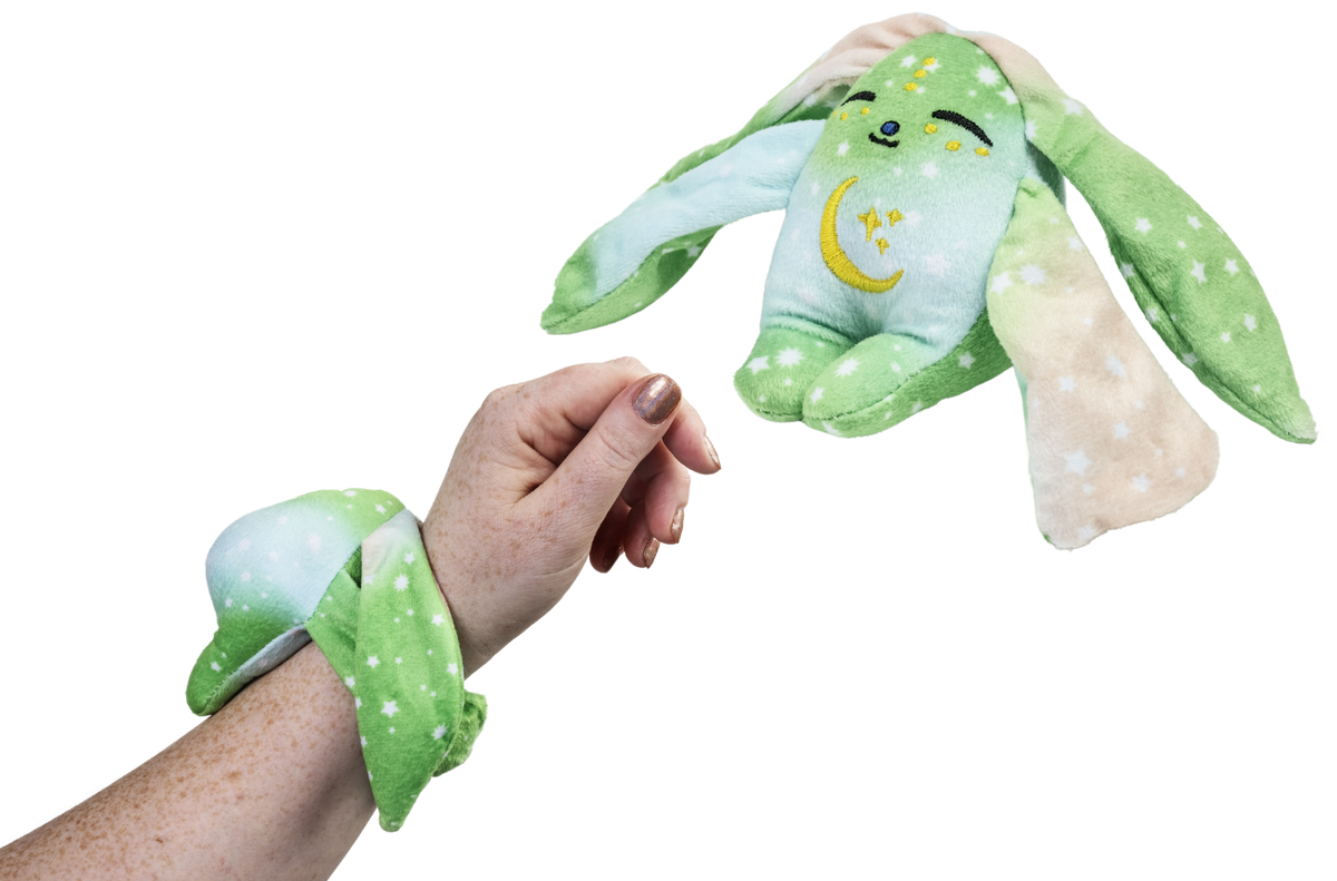 Moon Pals Clover Mini Wrist Hugger plush in soft green with adorable embroidered face and tiny arms, designed as a wrist accessory.