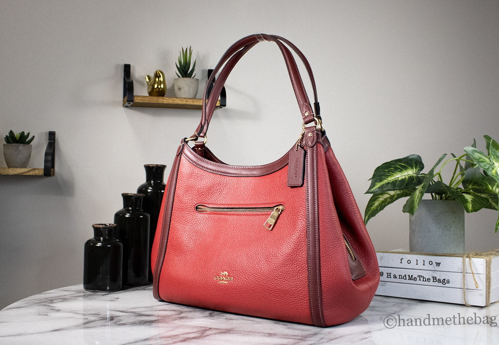 Coach Kristy red leather shoulder bag with triple compartments and apple-shaped design, featuring a sleek, stylish look.
