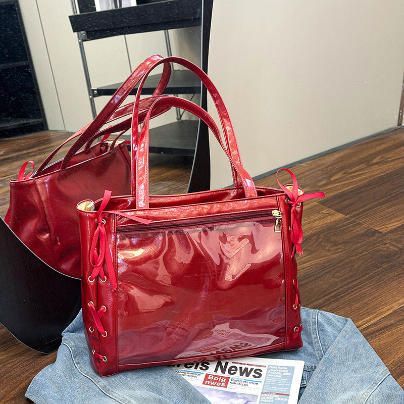 Large-capacity ribbon bow handheld shoulder bag in a structured design with a top handle and shoulder strap