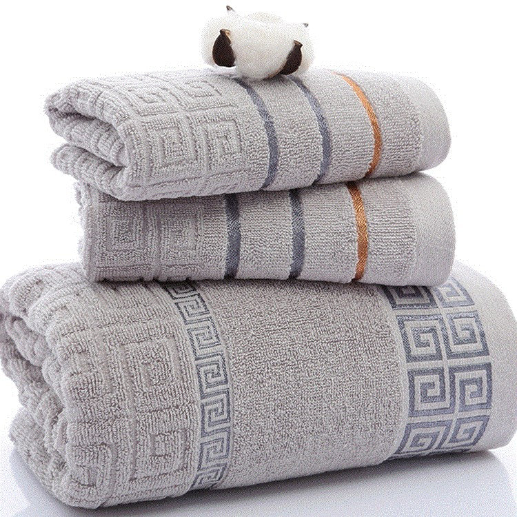 Three-piece cotton towel set in soft neutral colors, folded neatly for display