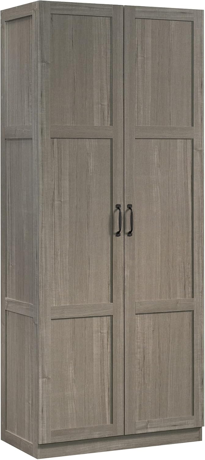 Sauder white storage cabinet with pantry and snack chip variety display in a modern kitchen setting