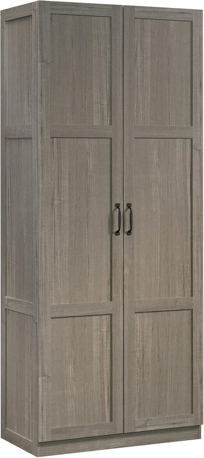 Sauder white storage cabinet with pantry and snack chip variety display in a modern kitchen setting
