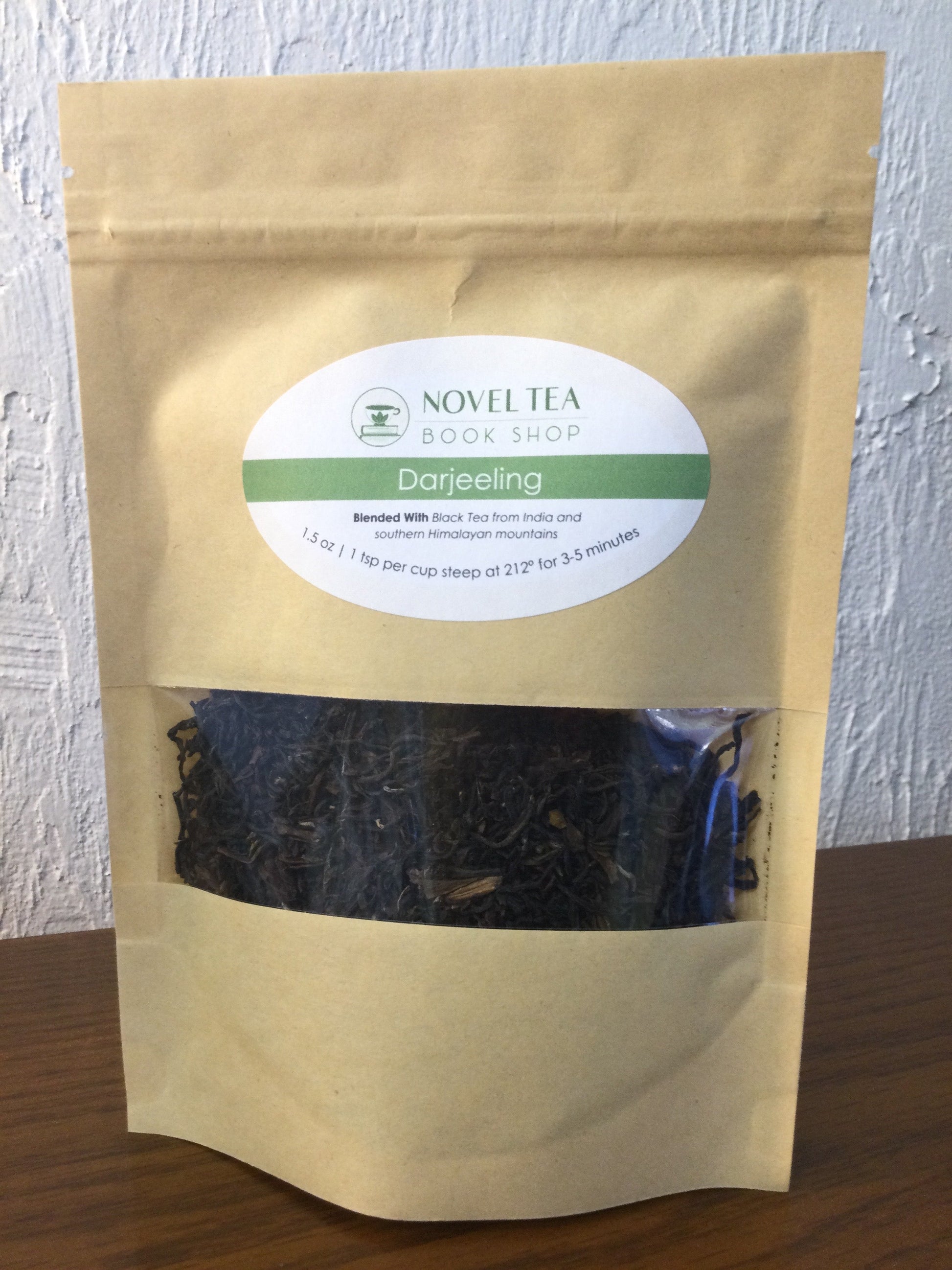 Loose leaf Darjeeling Sungma summer black tea from Novel Tea Book Shop, showcasing dark, aromatic tea leaves in a clear container.