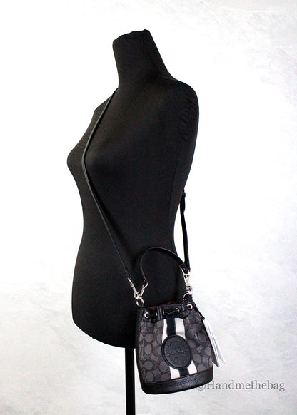 Coach Dempsey Mini Black Jacquard Canvas Patch Crossbody Bucket bag with adjustable strap and patchwork design.