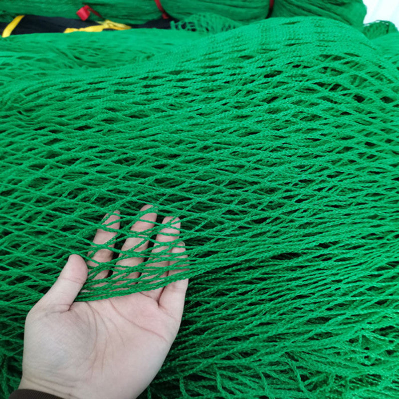 Green golf net displayed outdoors for golf practice and ball containment