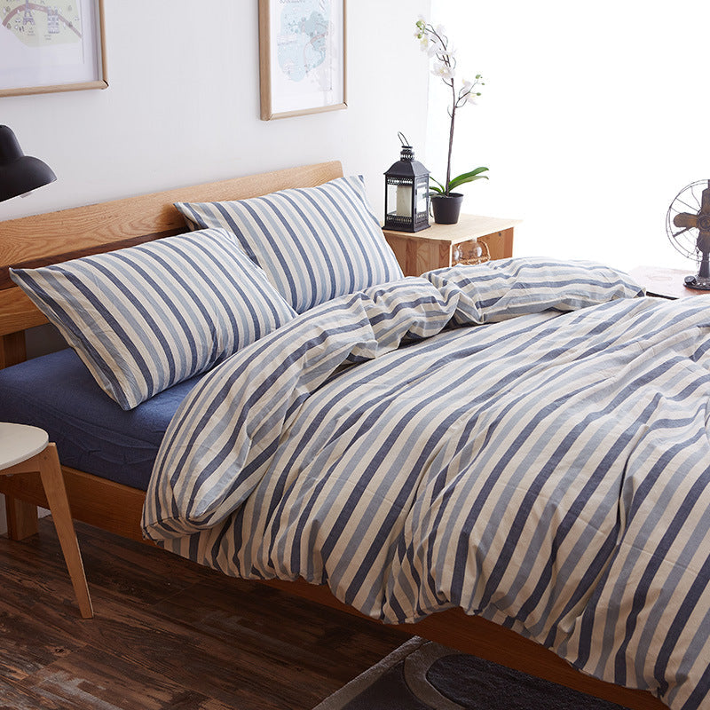 Pure cotton four-piece bed sheet set in soft, neutral fabric with matching pillowcases and fitted sheet