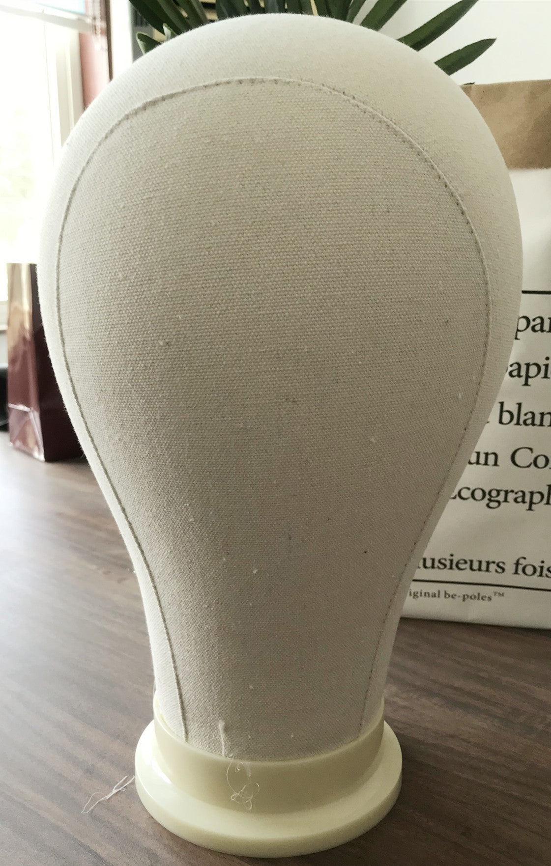 Canvas head mold for finishing wig shape, displayed upright for styling and shaping wigs
