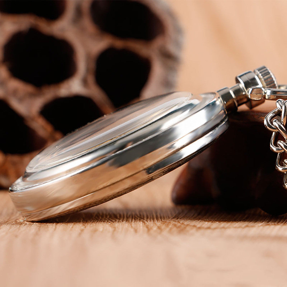 Carved mechanical pocket watch with detailed engraved cover and classic metal finish
