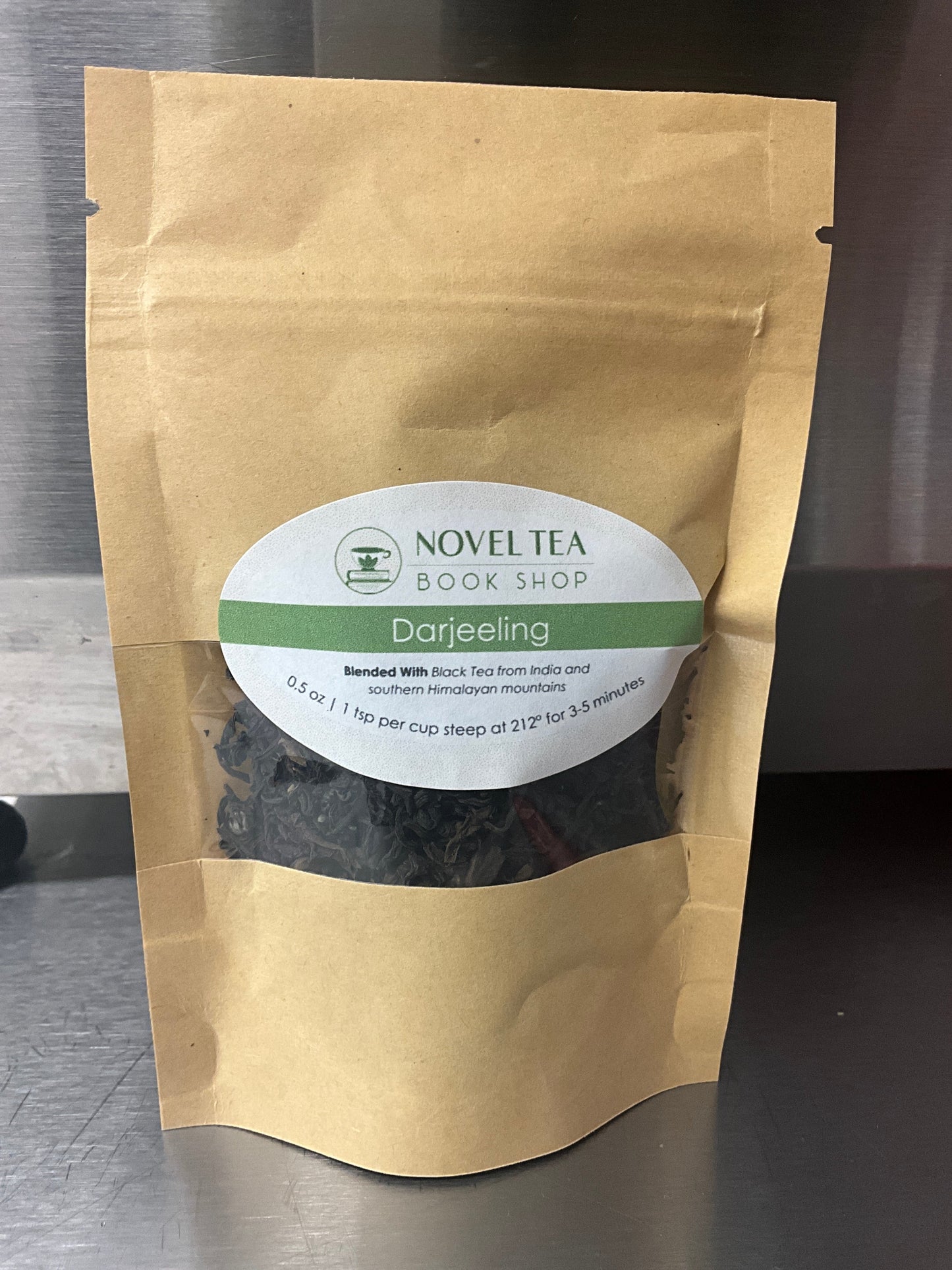 Loose leaf Darjeeling Sungma Summer Black Tea in a clear jar, showcasing dark tea leaves from Novel Tea Book Shop