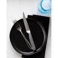 Set of 8 Dura Living gray steak knives with stainless steel blades and ergonomic handles, arranged on a wooden surface.