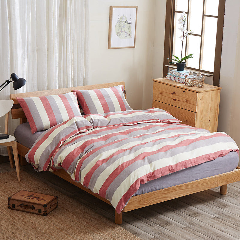 Pure cotton four-piece bed sheet set in soft, neutral fabric with matching pillowcases and bedding pieces