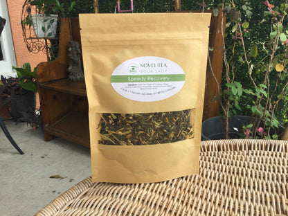 Loose leaf wellness tea from Novel Tea Book Shop called Speedy Recovery, featuring dried herbs and tea leaves in a clear jar.