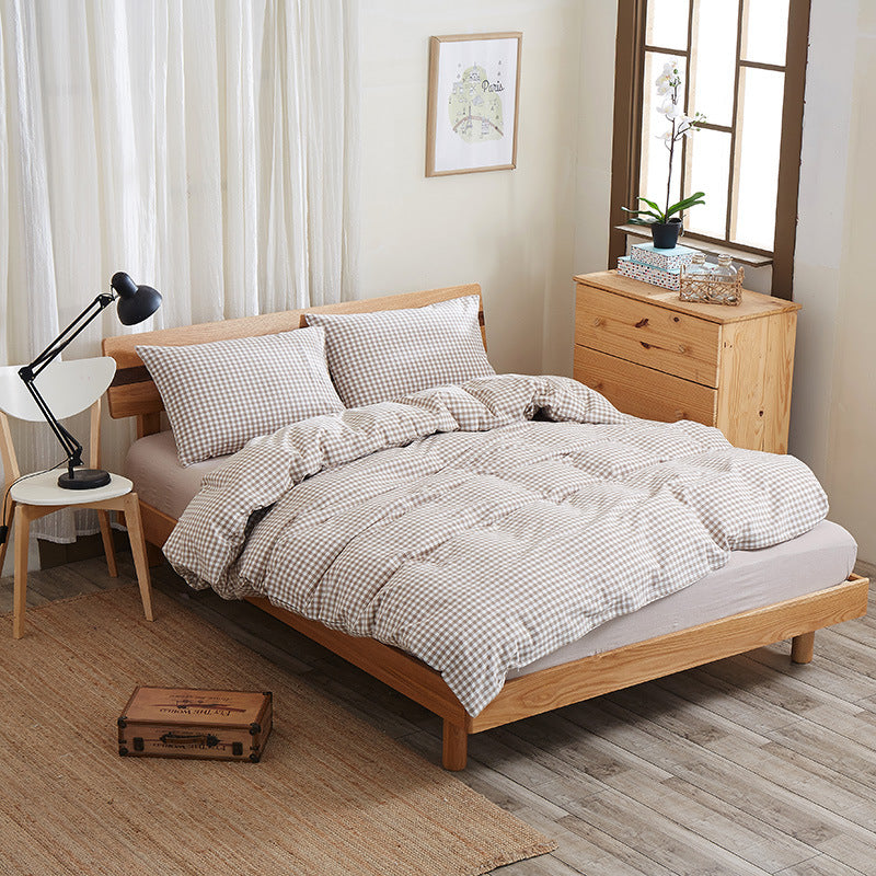 Pure cotton four-piece bed sheet set in a soft, neutral design neatly displayed on a bed