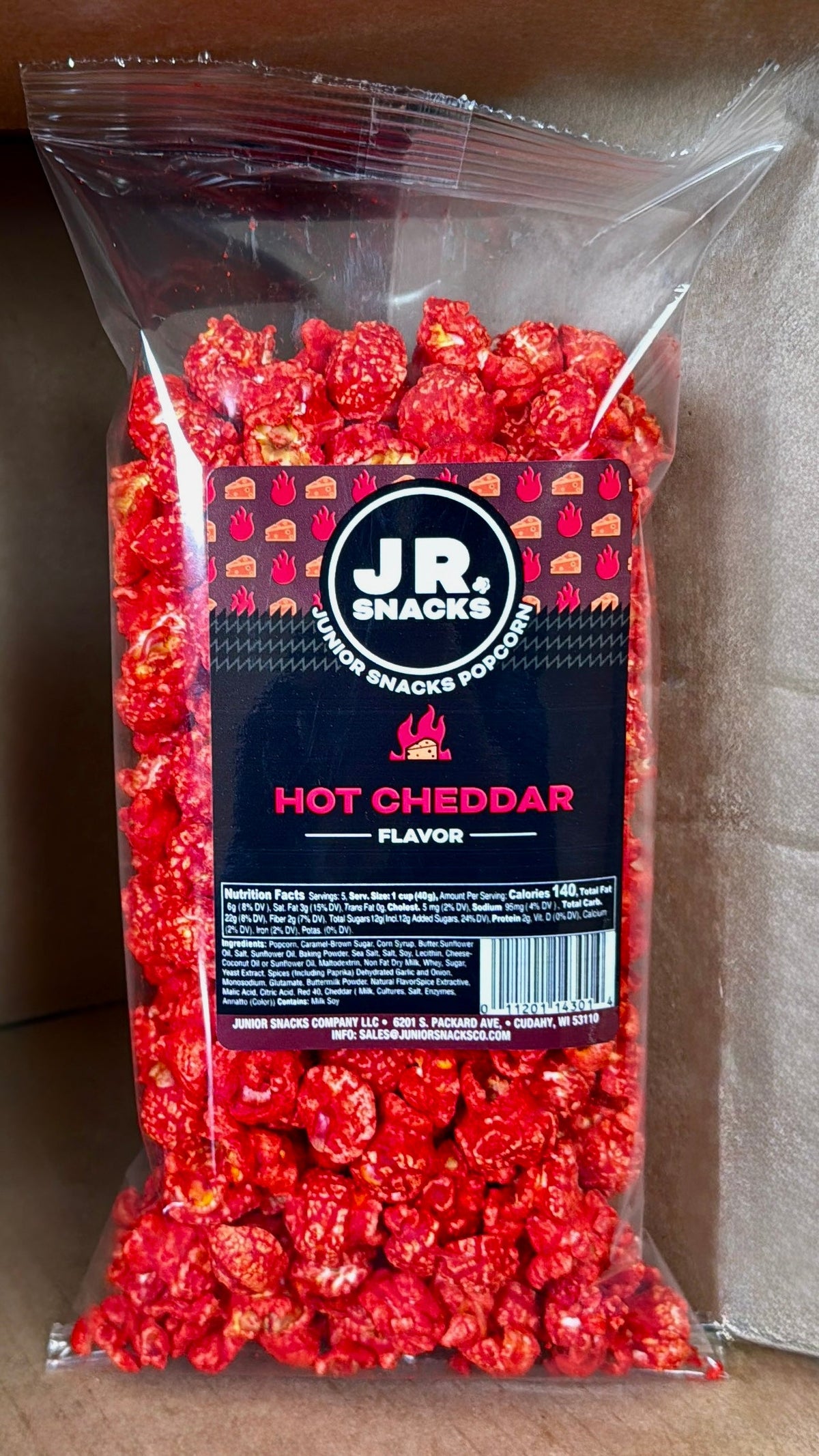 Junior Snacks Co. Hot Cheddar snack bag featuring colorful packaging and the Junior Snacks Company logo.
