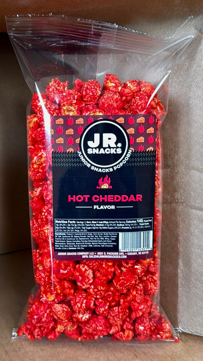 Junior Snacks Co. Hot Cheddar snack bag featuring colorful packaging and the Junior Snacks Company logo.
