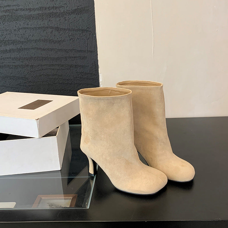 Solid-color commuter-style versatile booties in a low ankle design, side view