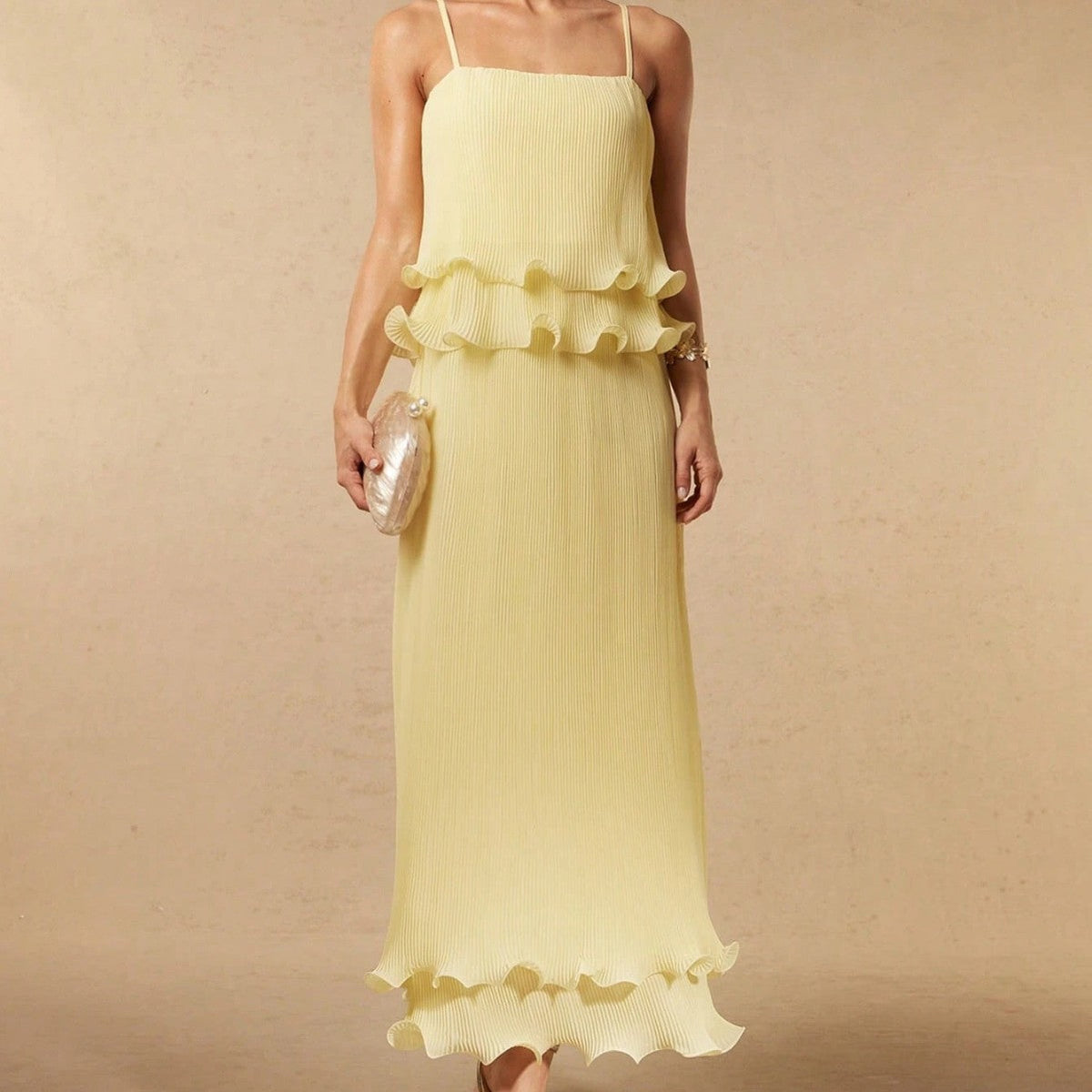 Pleated yellow strap spliced tiered long dress with flowing silhouette and adjustable shoulder straps