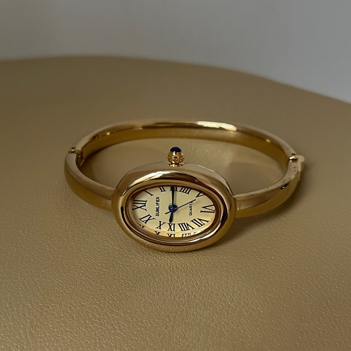 Women's oval Roman-numeral bracelet watch with metallic band and classic dial