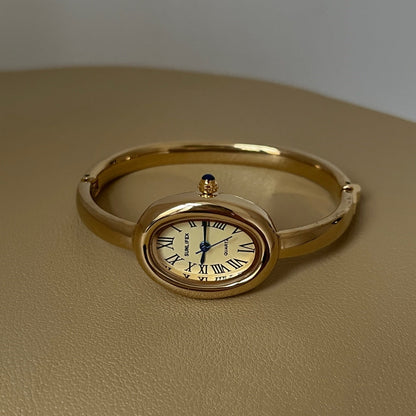 Women's oval Roman-numeral bracelet watch with metallic band and classic dial
