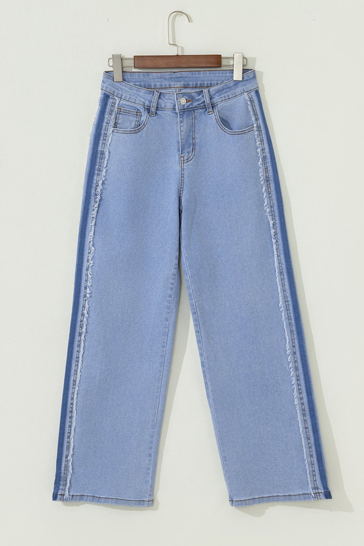 Light blue Sofiya Patchwork Shift Jeans by Threaded Pear with patchwork details and relaxed fit, laid flat on a white background.