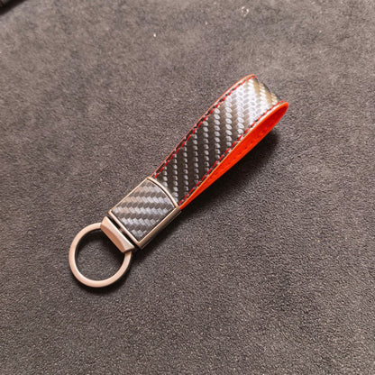 Carbon-fiber-pattern car keychain pendant with sleek black textured finish