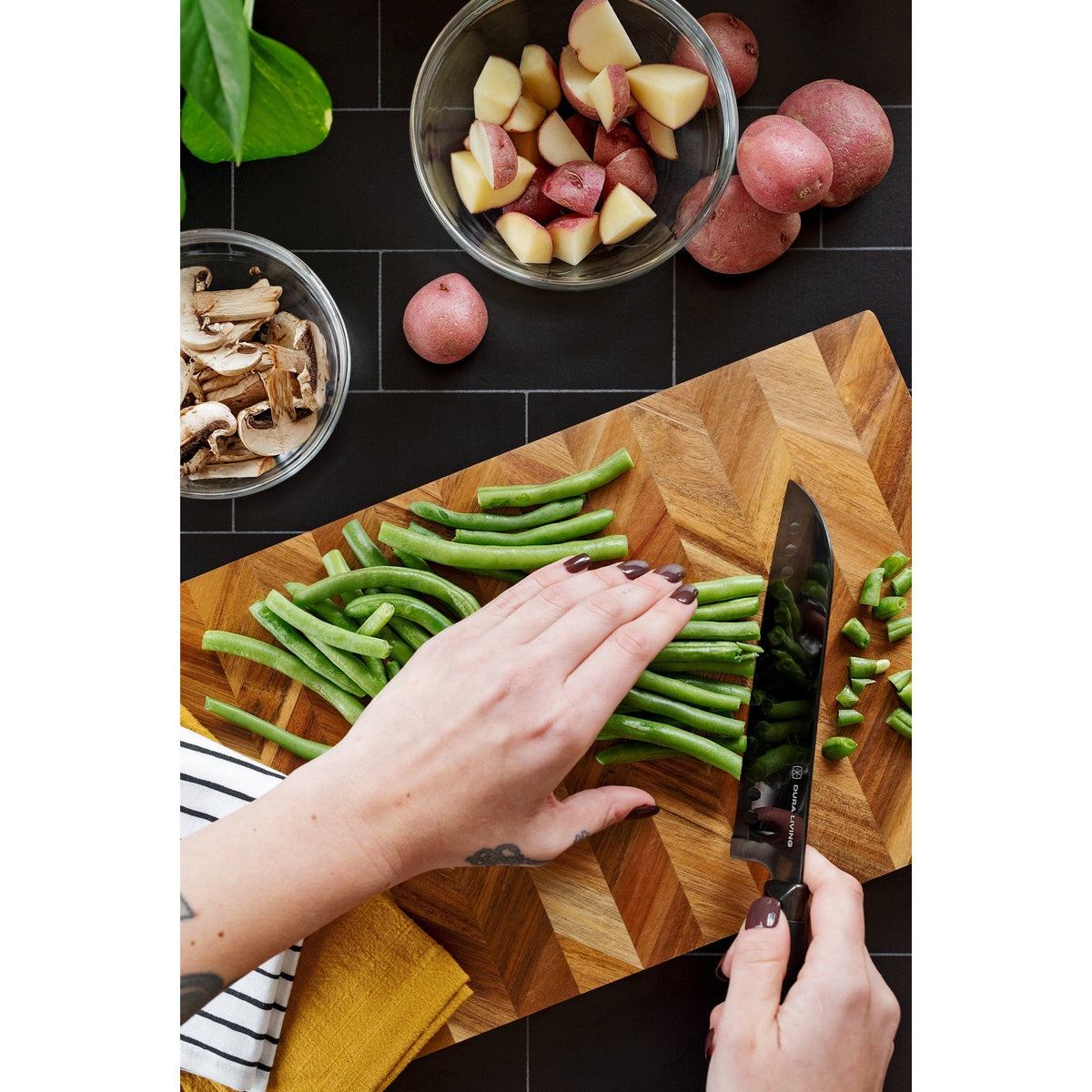 Dura Living Titan 7-inch black Santoku knife with a sharp stainless steel blade and ergonomic handle for precise slicing.