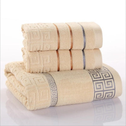 Three-piece cotton towel set in soft neutral tones, folded neatly for display