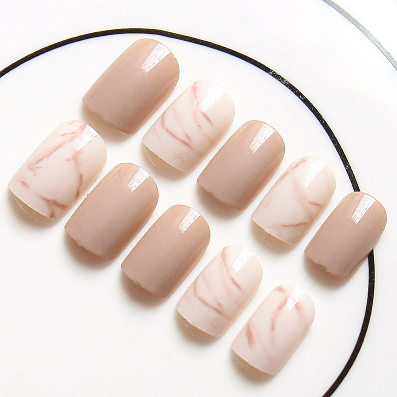 Light khaki smudge false nails in a neutral abstract design, close-up product image