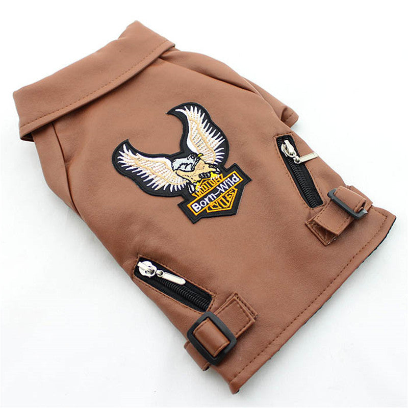 Small dog wearing a brown embroidered eagle leather jacket with sticker-style detailing