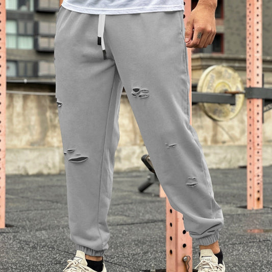 Ripped sweat-wicking fitness jogger pants in a tapered athletic style, showing breathable fabric and zippered details