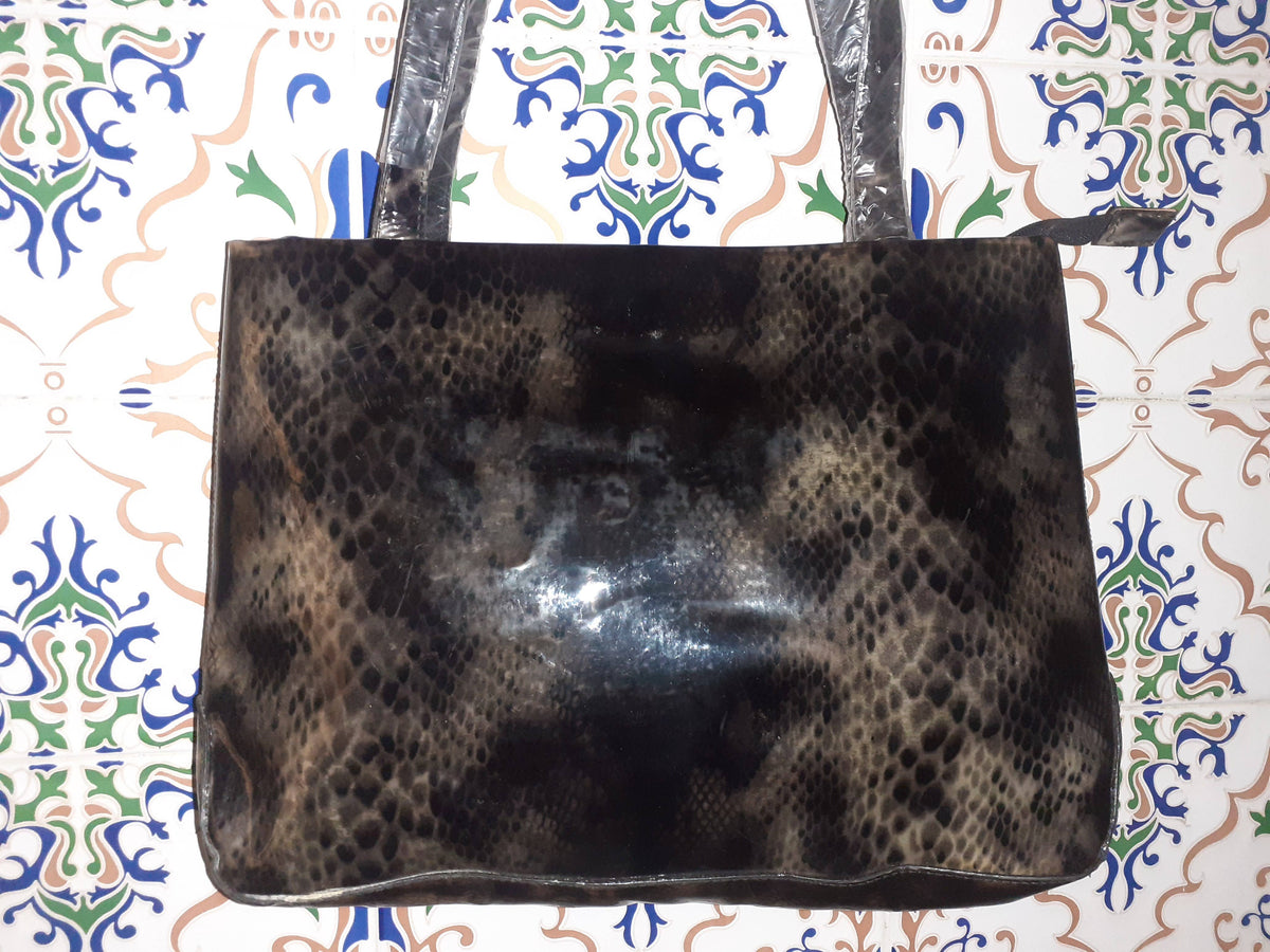 Handmade women's handbag with sturdy handles, featuring a stylish, natural leather finish and detailed craftsmanship.