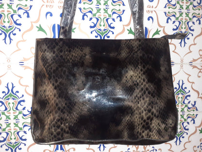 Handmade women's handbag with sturdy handles, featuring a stylish, natural leather finish and detailed craftsmanship.