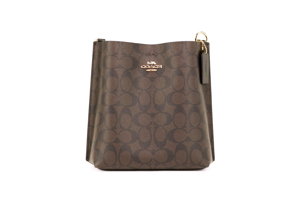 Coach Mollie 22 small brown and black coated canvas bucket crossbody handbag with adjustable strap and gold-tone hardware.