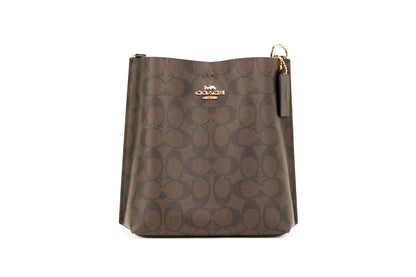 Coach Mollie 22 small brown and black coated canvas bucket crossbody handbag with adjustable strap and gold-tone hardware.
