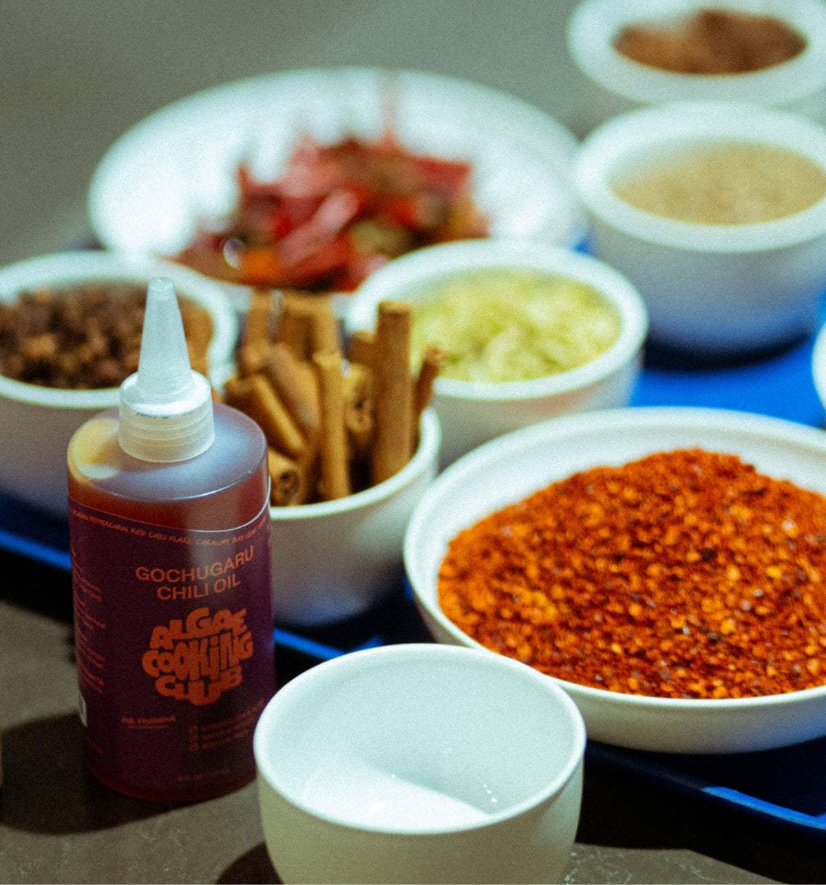 Algae Cooking Club Chef Squeeze Trio oil bottles with colorful labels, arranged on a kitchen countertop.