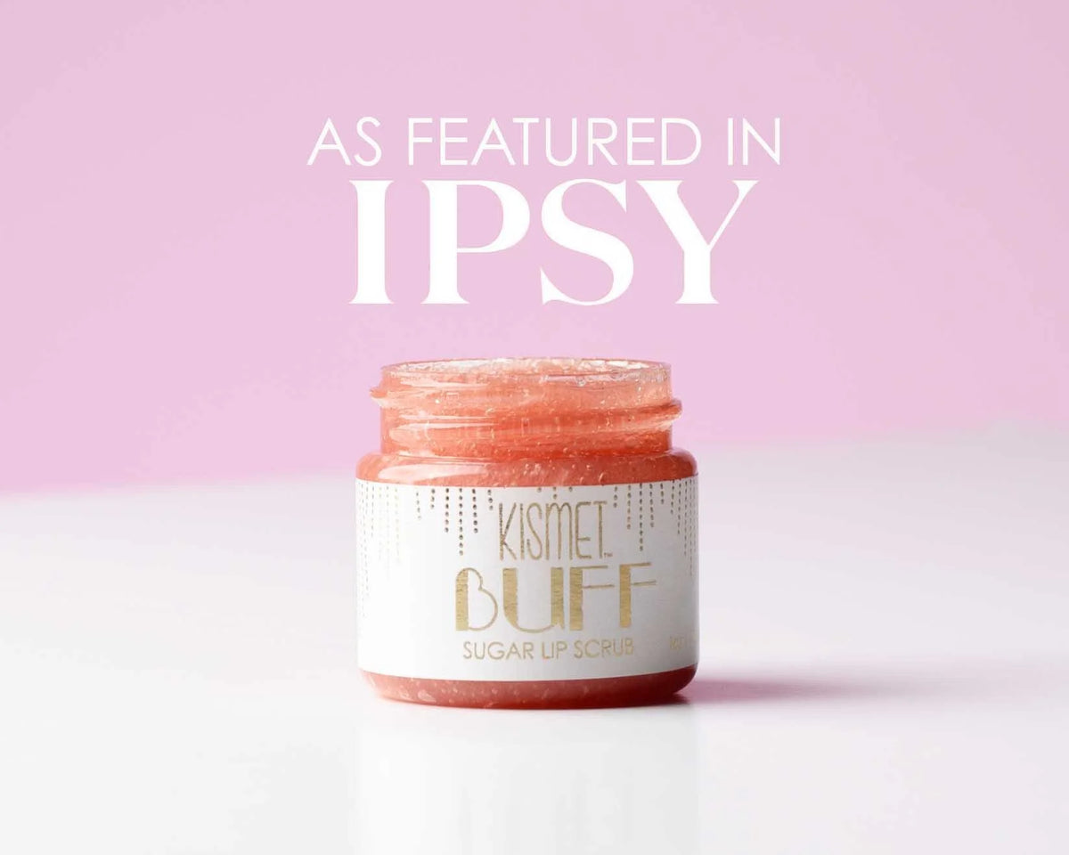 Kismet Buff All-Natural Lip Scrub in a clear jar with a wooden spatula, showcasing its natural exfoliating ingredients.