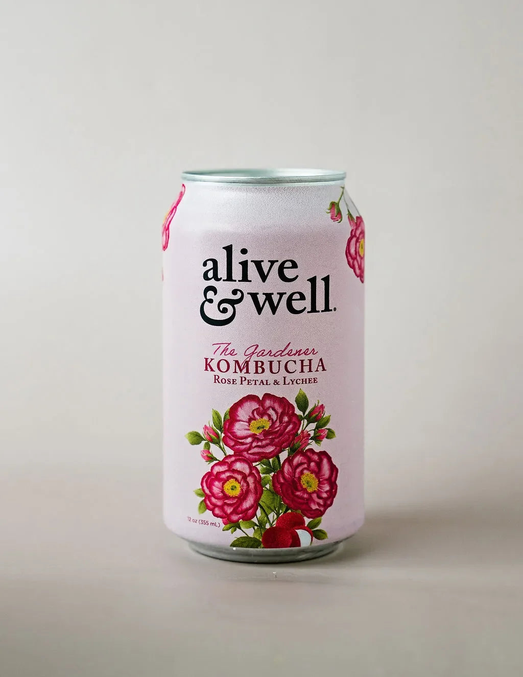 Organic Rose Petal and Lychee Kombucha by Alive & Well, 6-pack, featuring a clear bottle with a pink and purple label and fresh ingredients.