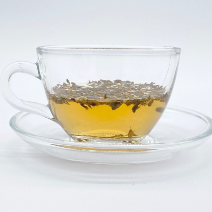 Loose leaf Arabica herbal tea from Novel Tea Book Shop, showcasing fresh, dried tea leaves in a natural setting.