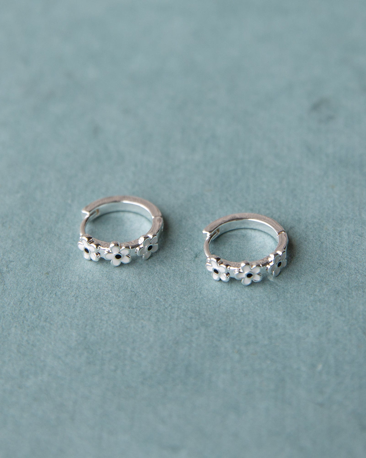 Silver In Bloom huggie hoop earrings by Downeast featuring delicate floral design and small hoop style.