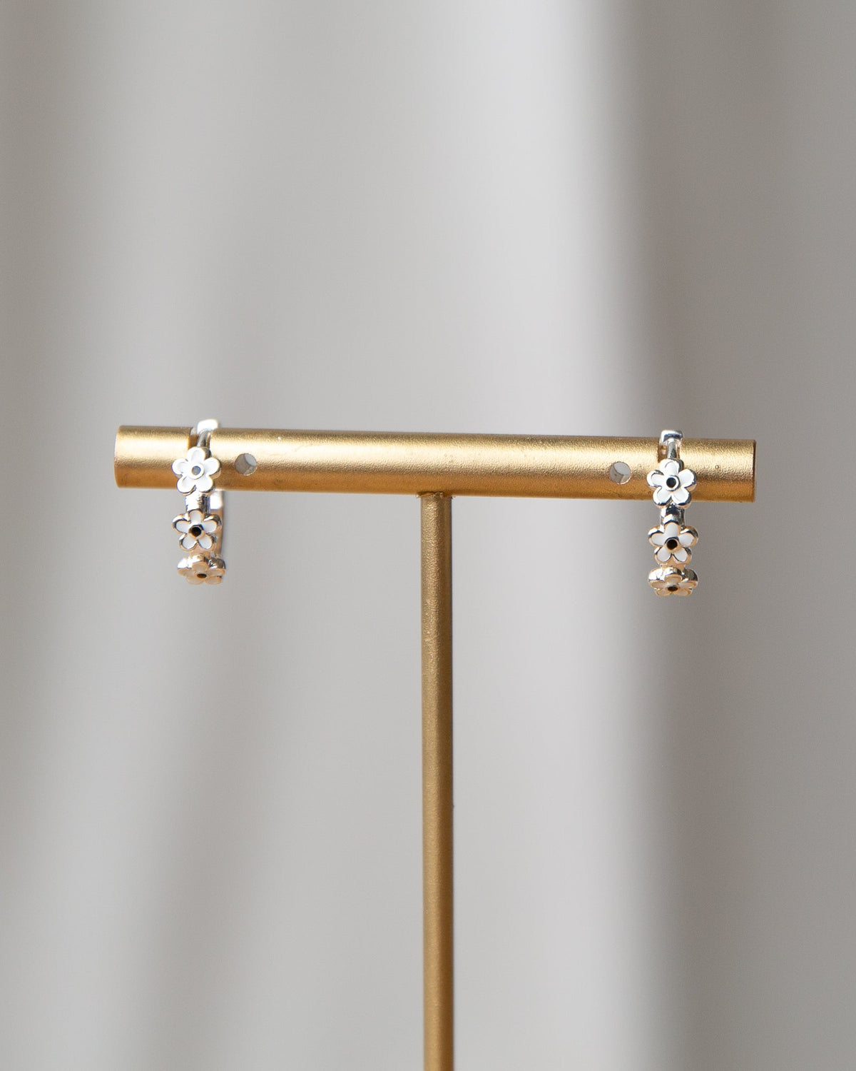 Silver In Bloom Huggie Hoop earrings by Downeast featuring delicate floral design and small hoop style.